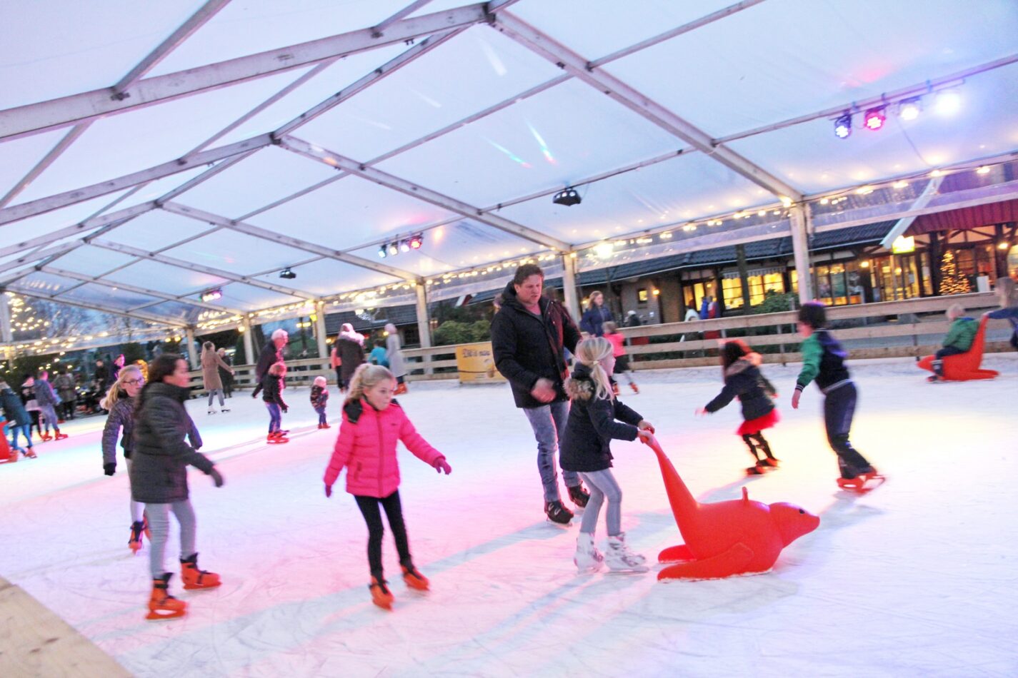 schaatsende kinderen met schaatshulp accessoires