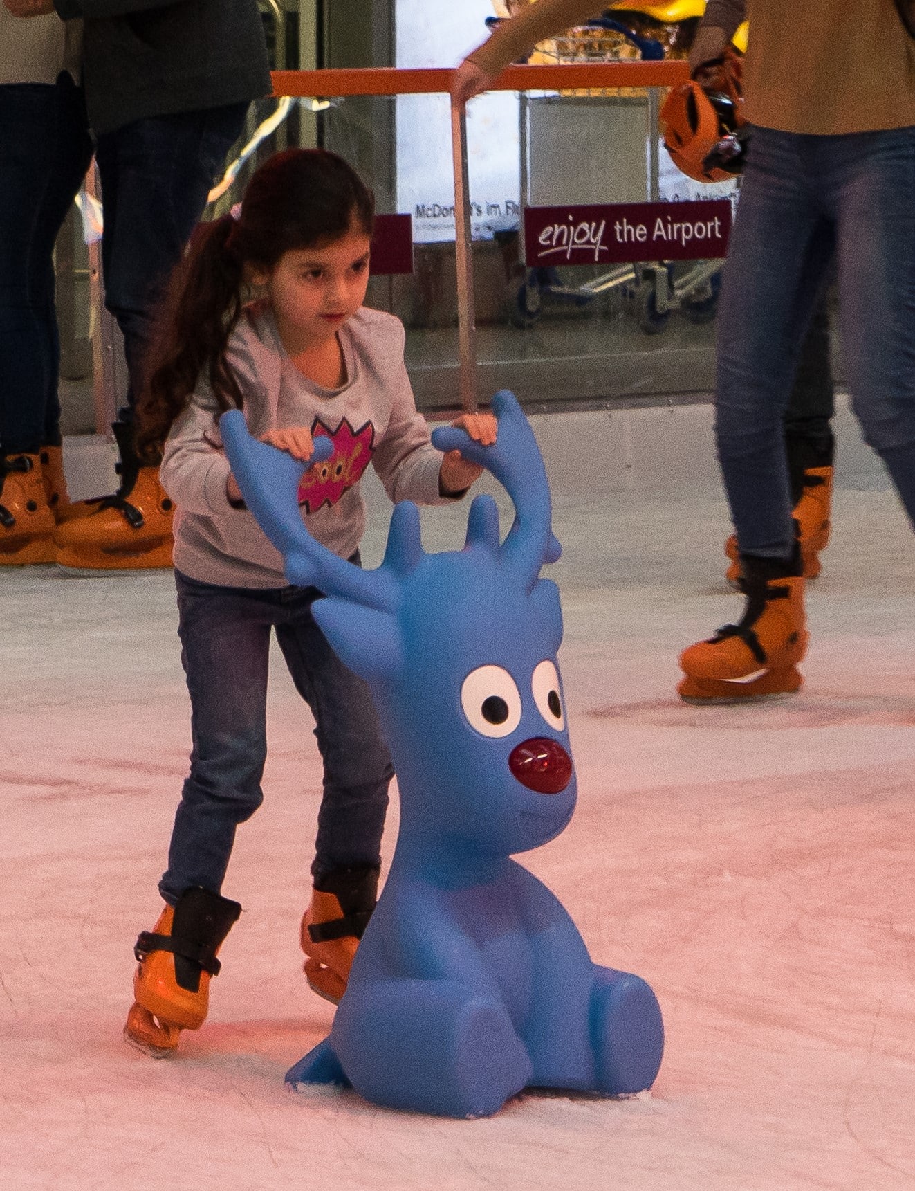 child ice skating with tommy the reindeer ice skating aid